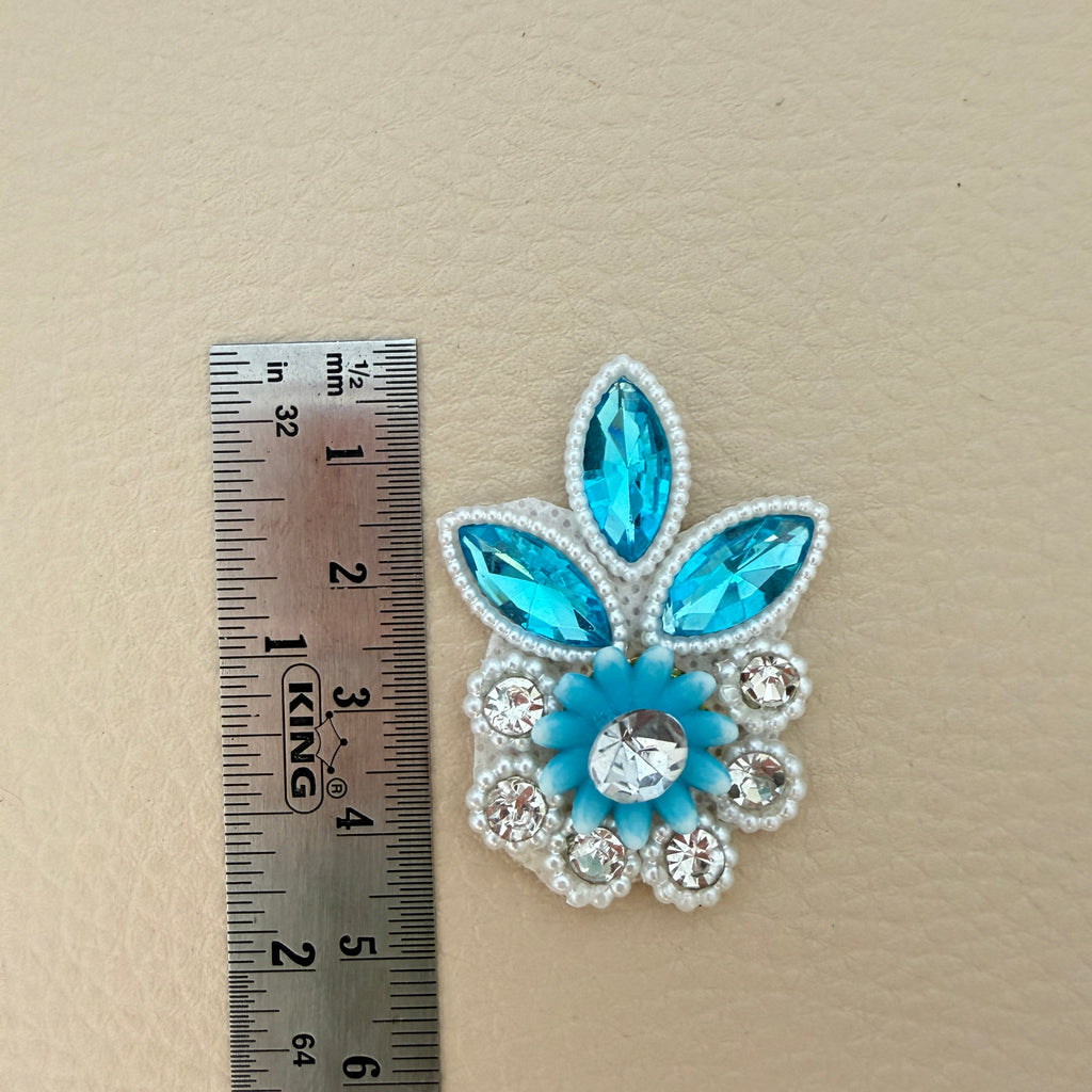 Sky blue crystal and pearl rhinestone applique patch held in hand to show its size and details