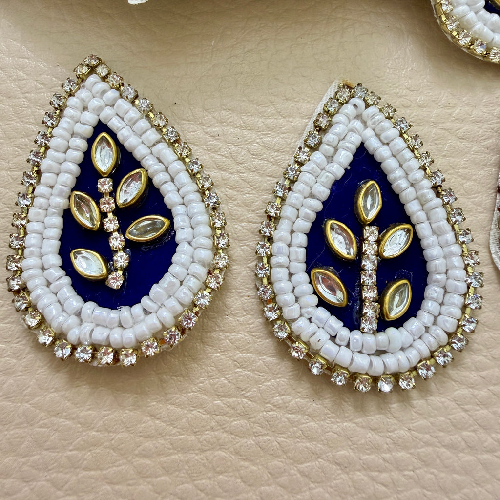 Close-up of two navy blue beaded kundan teardrop patches