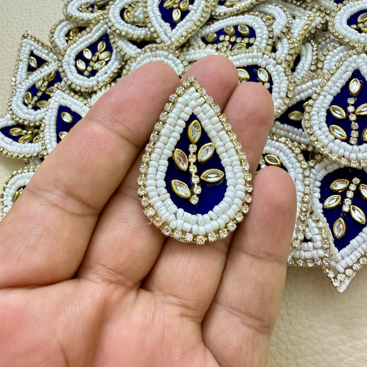 Navy blue teardrop kundan patch held in hand