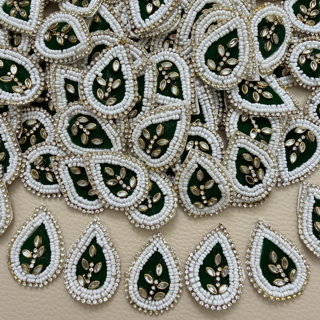 Bottle green kundan teardrop patch next to ruler showing size
