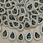 Bottle green kundan teardrop patch next to ruler showing size