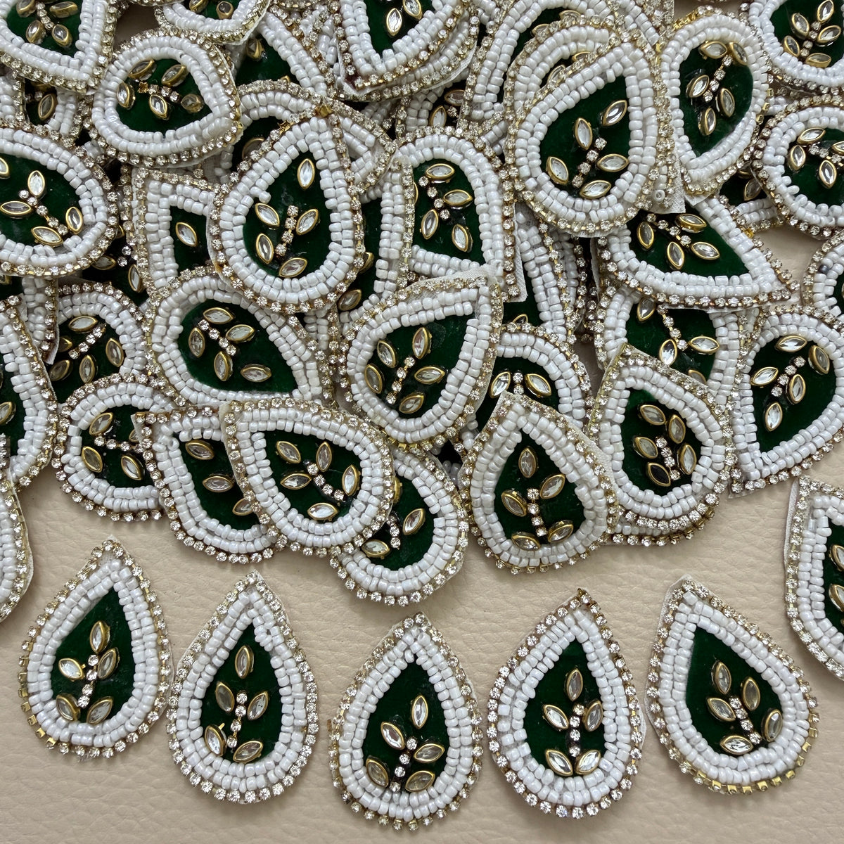 Bottle green kundan teardrop patch next to ruler showing size