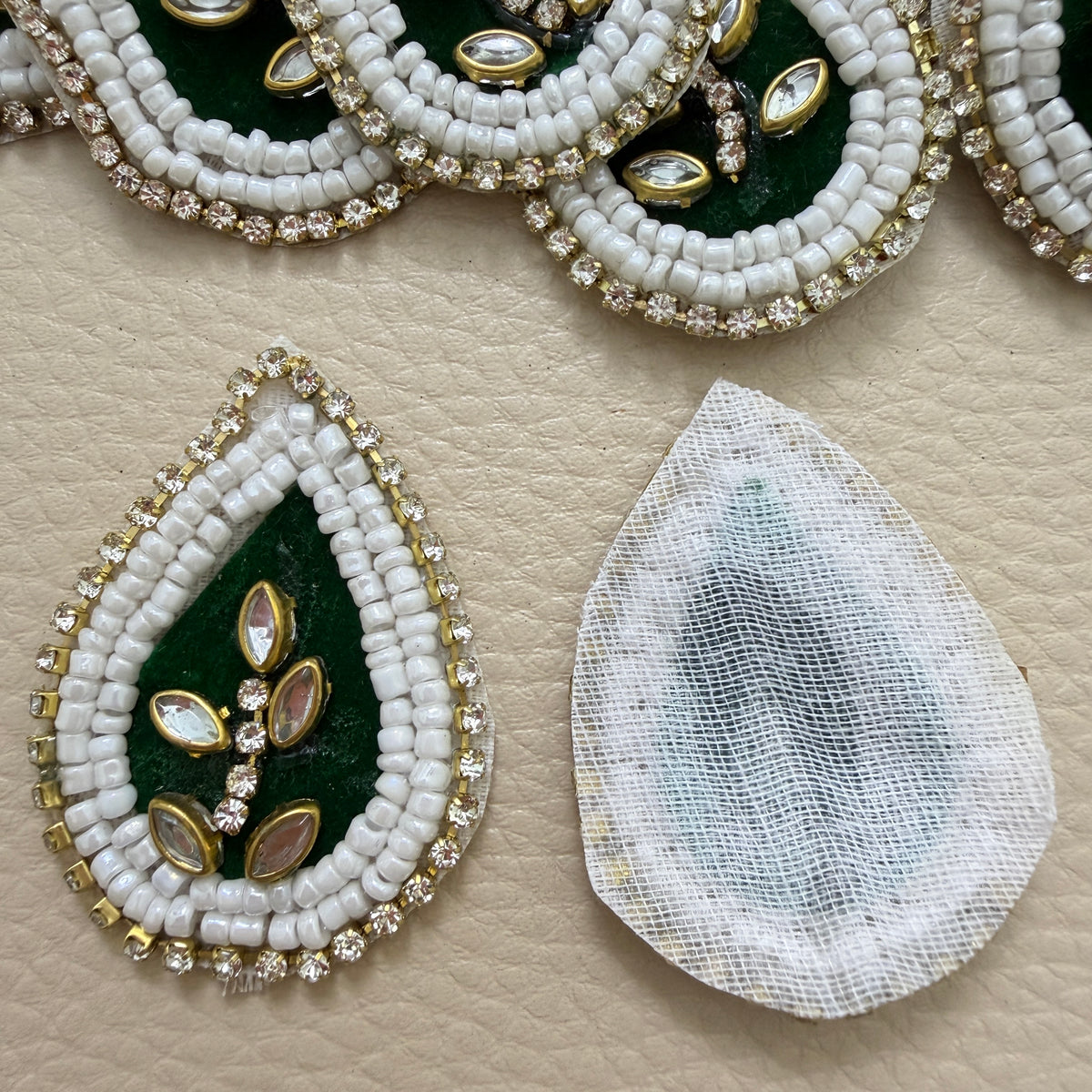 Pile of bottle green teardrop kundan motif patches