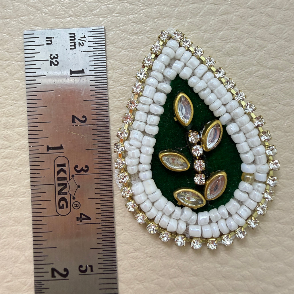 Bottle green kundan teardrop patch held in hand