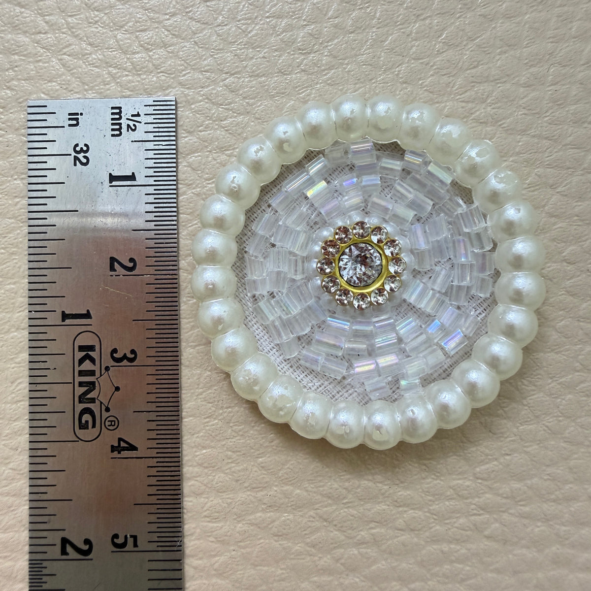 White pearl bugle bead patch next to ruler showing size