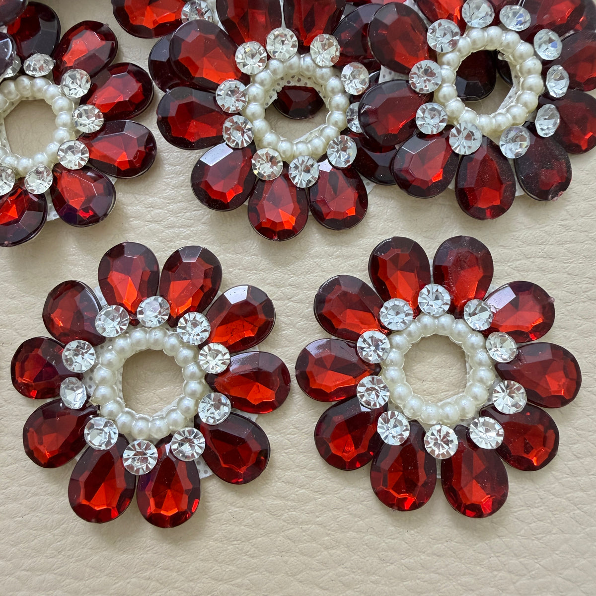 Close-up of maroon teardrop stone flower patches with pearls