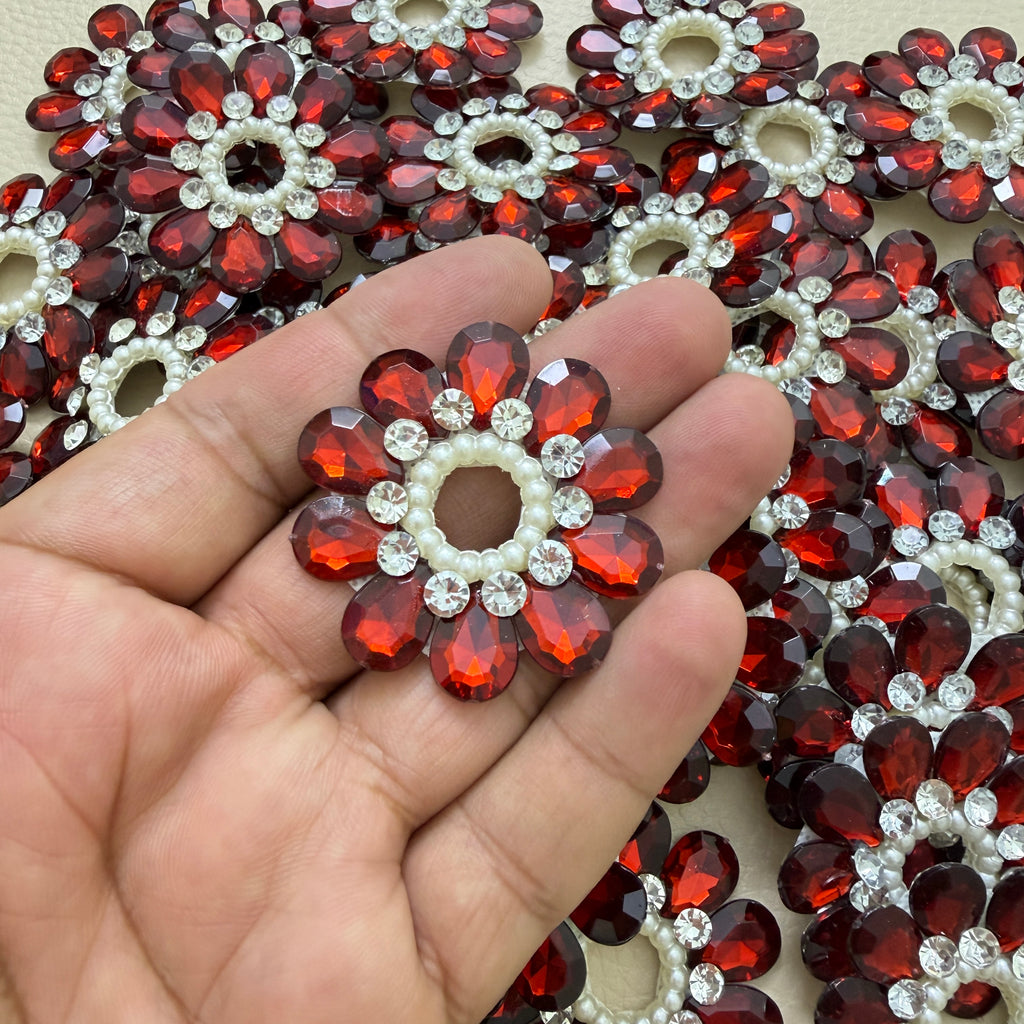 Maroon rhinestone flower patch held in hand