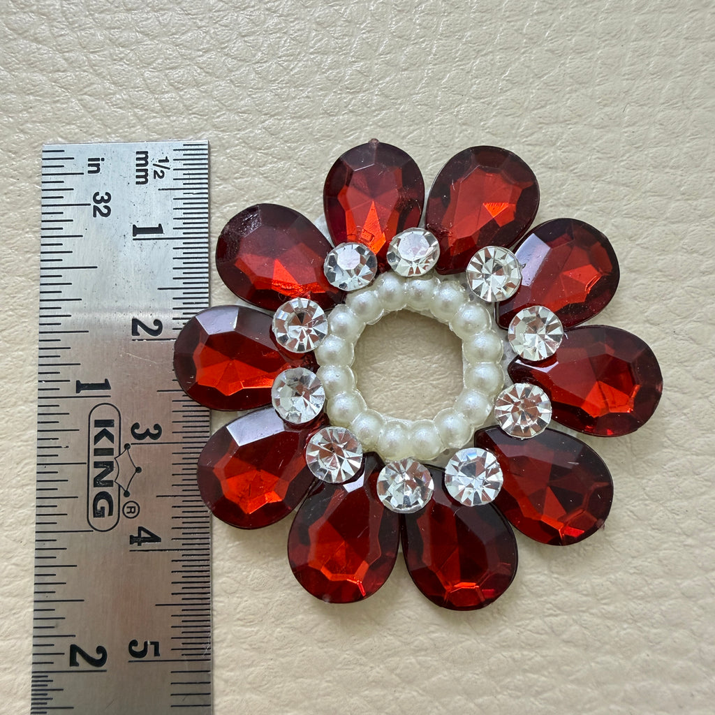 Maroon rhinestone flower patch next to ruler showing size