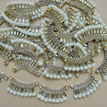 Antique gold-tone rhinestone and pearl crescent motif patches close-up