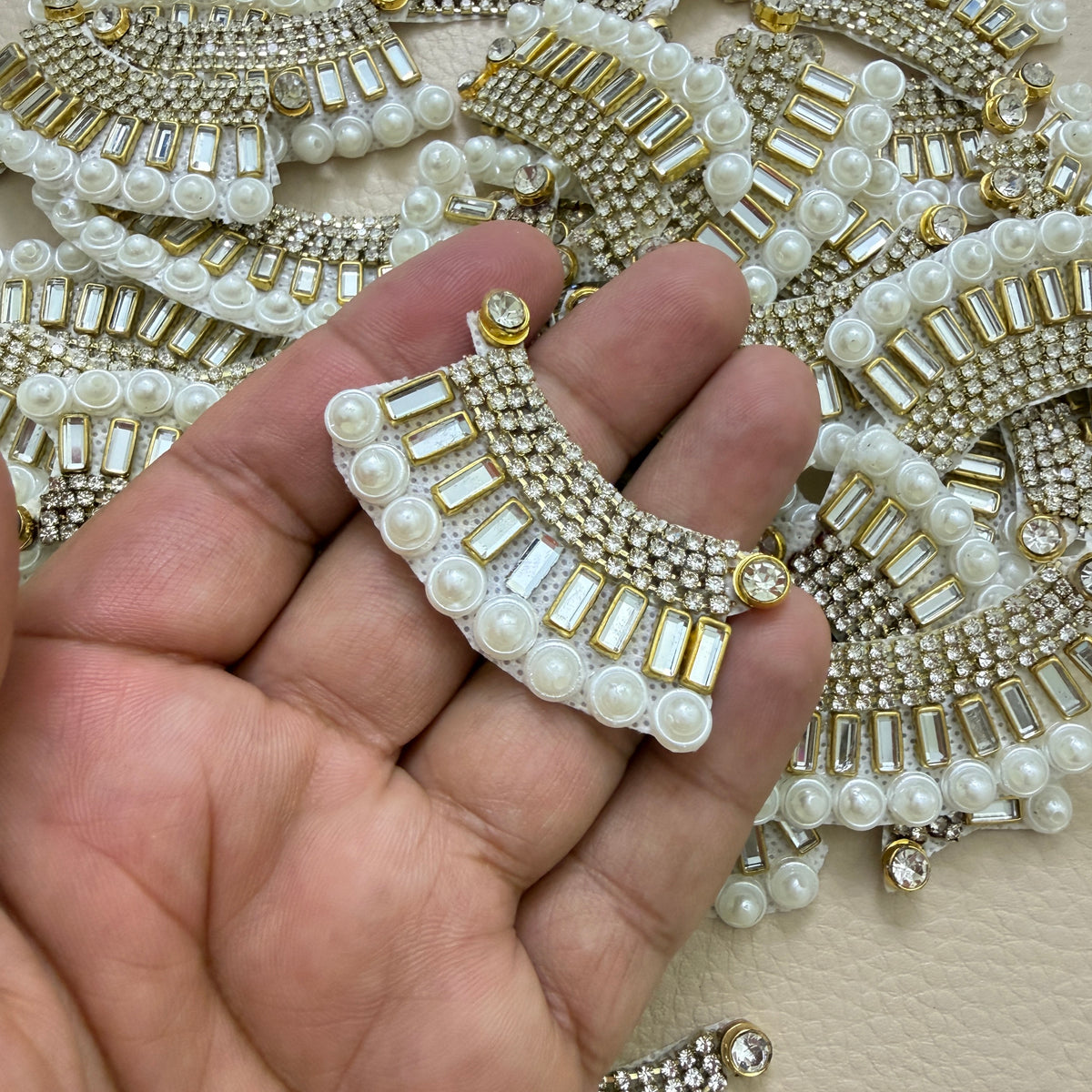 Single rhinestone and pearl crescent patch beside ruler for size reference