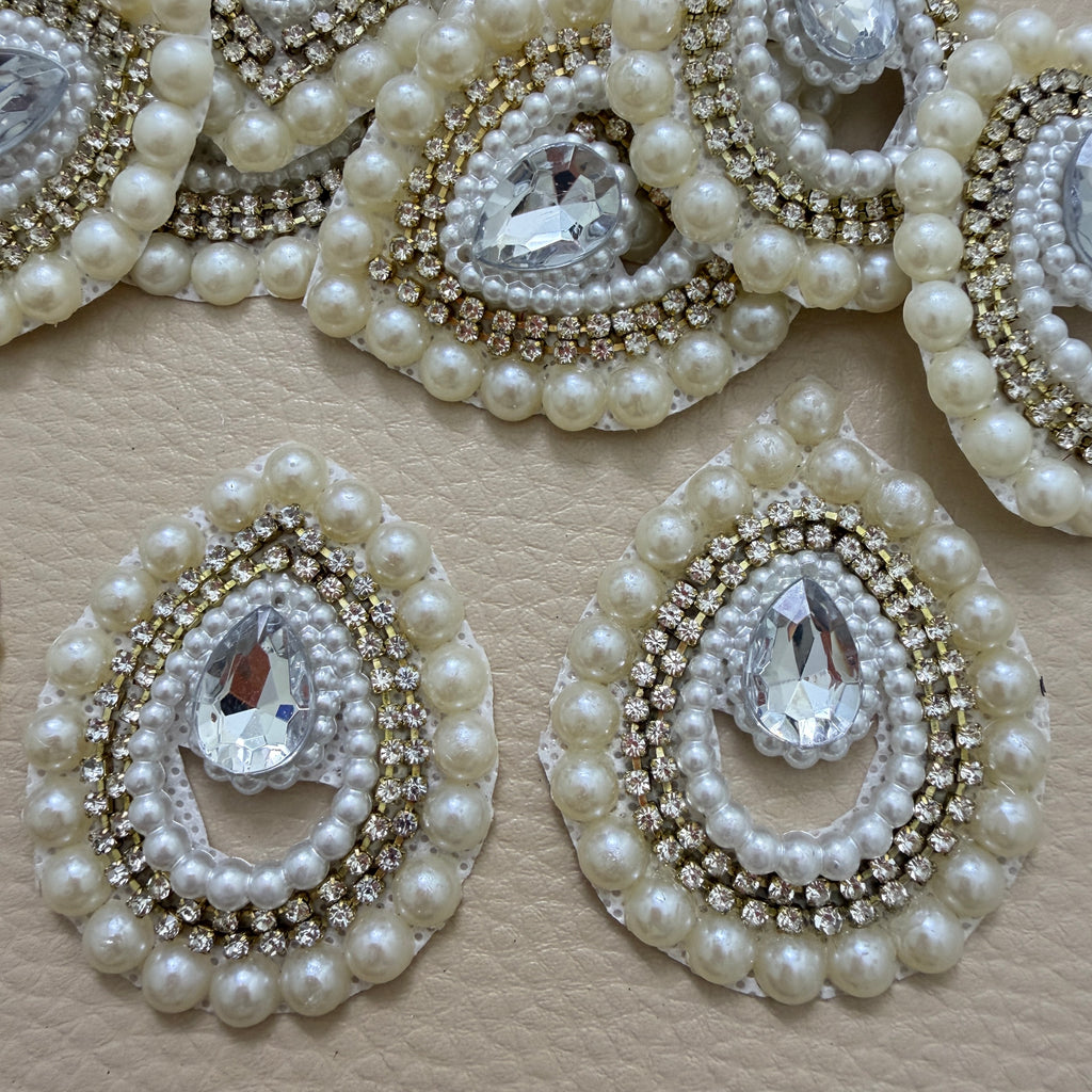 Teardrop motif pearl and rhinestone patch beside ruler for size