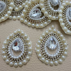 Teardrop motif pearl and rhinestone patch beside ruler for size