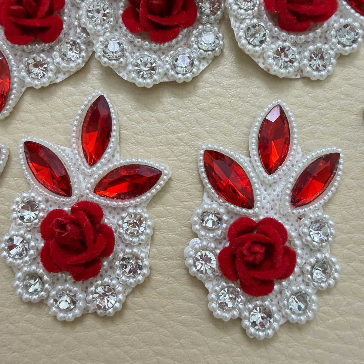 Front and white mesh backing of a red rose rhinestone patch