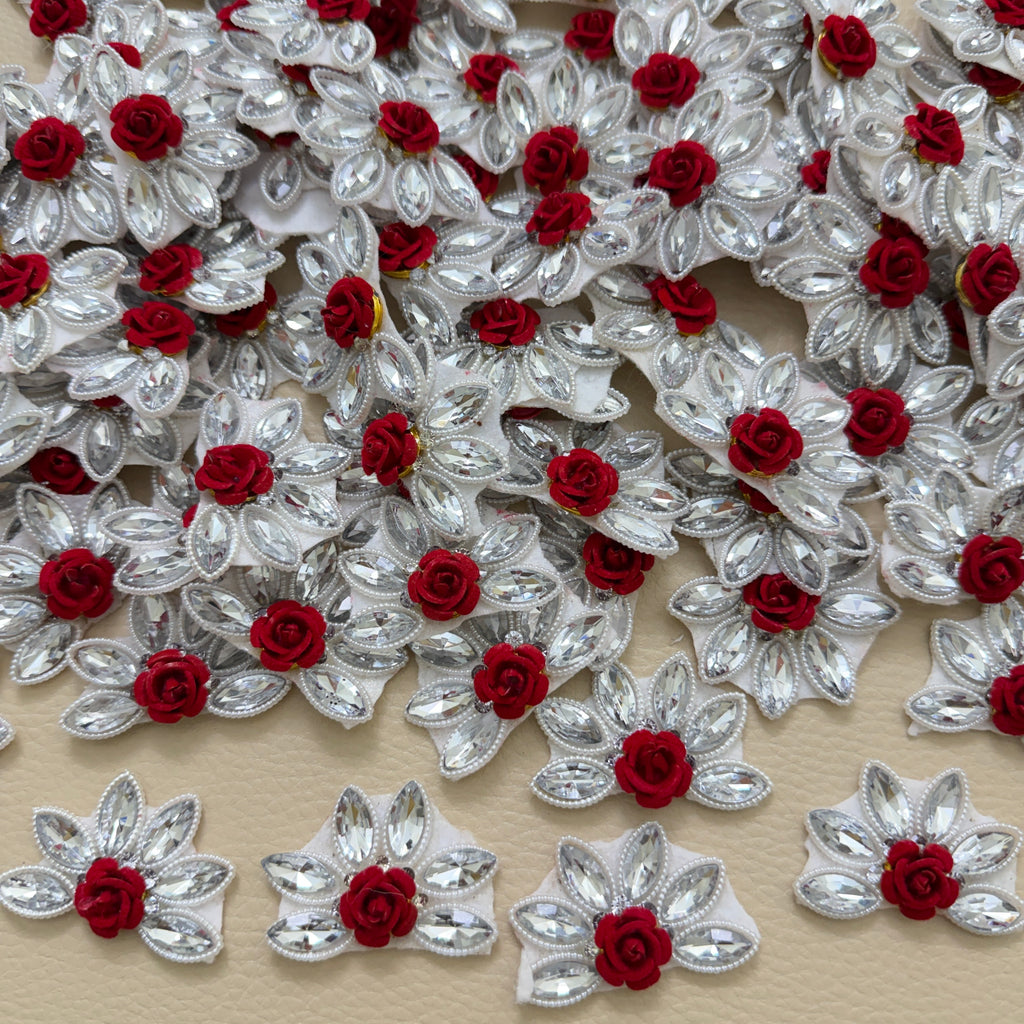 Maroon velvet rose rhinestone flower motif patch held in hand showing size