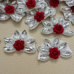 Maroon rose and clear marquise rhinestone flower patches arranged on a beige surface