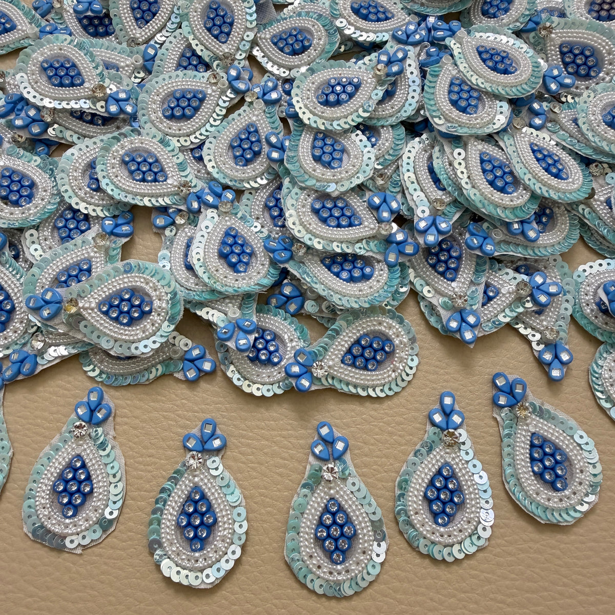 Front and white mesh backing of blue pearl and sequin teardrop patch