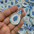 Close-up of blue teardrop patches with white pearl-look beads and pale blue sequin borders