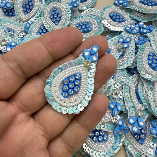Close-up of blue teardrop patches with white pearl-look beads and pale blue sequin borders