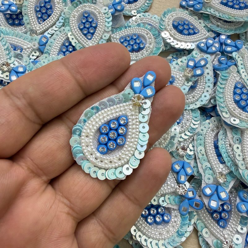 Close-up of blue teardrop patches with white pearl-look beads and pale blue sequin borders
