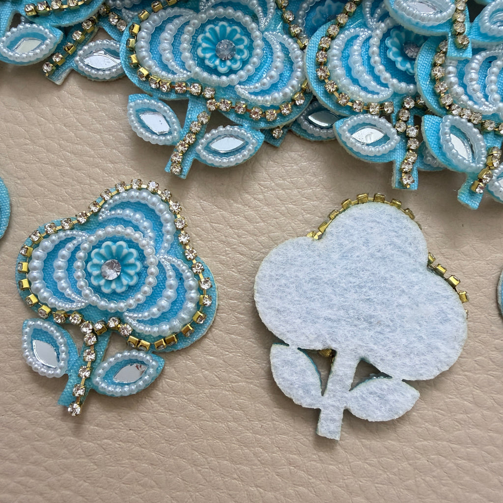 Sky blue floral applique patch beside a ruler for size reference
