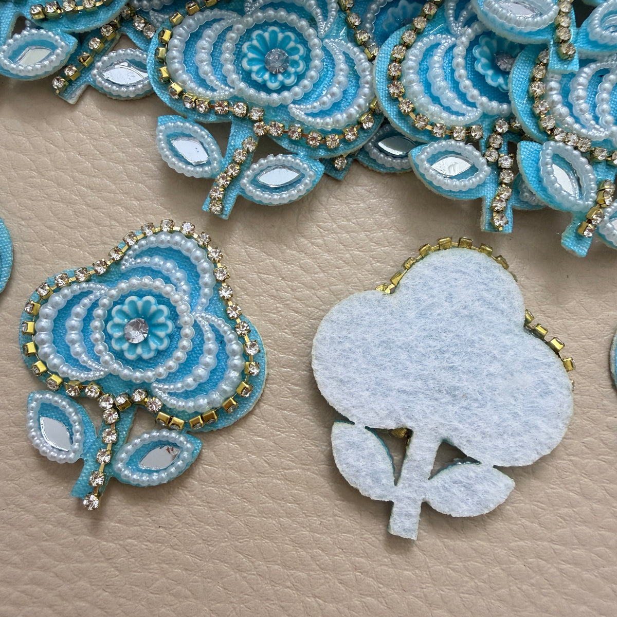 Sky blue floral applique patch beside a ruler for size reference