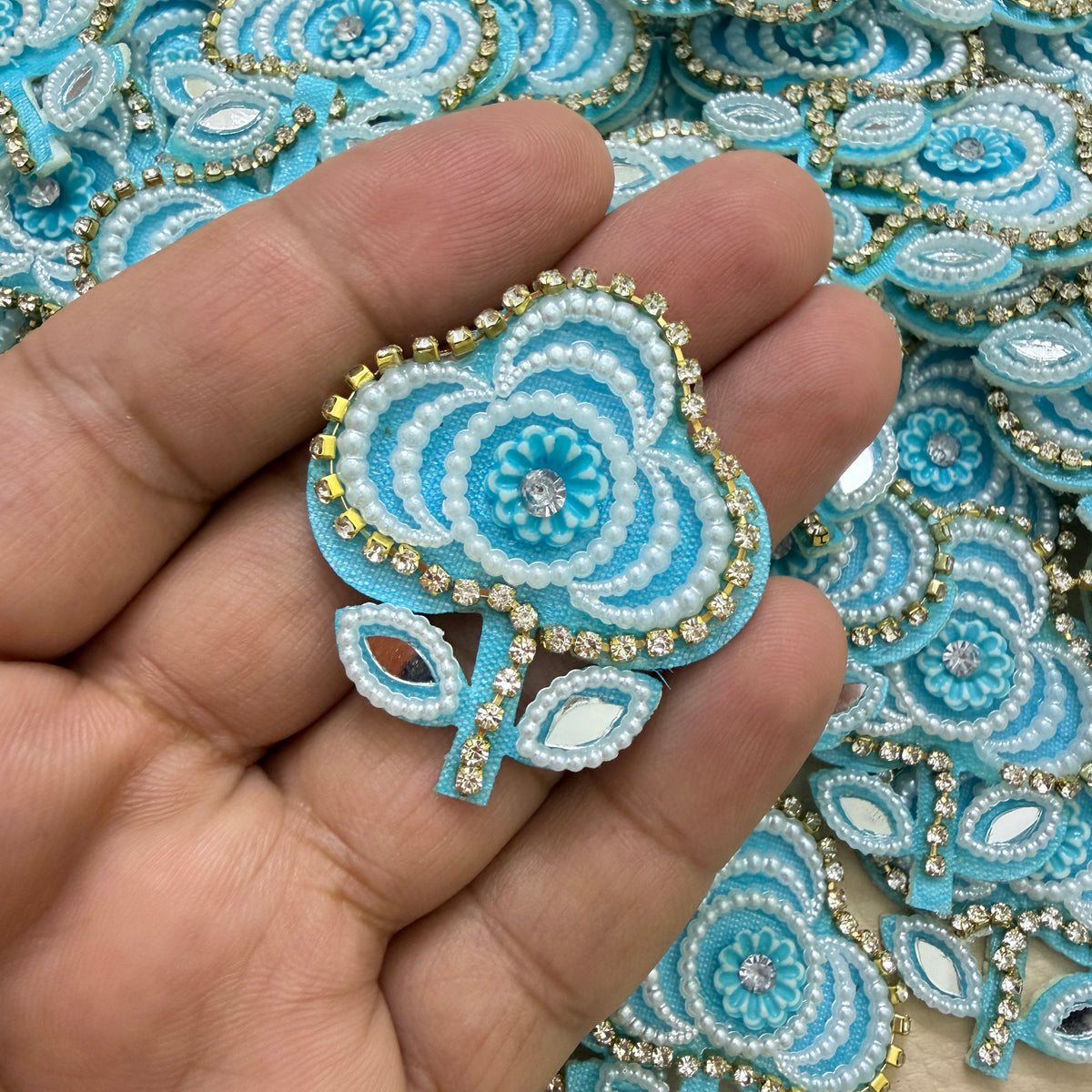 Sky blue floral patches with white pearl-look beads, sparkling borders and reflective leaf details