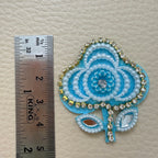 Front and white fabric backing of sky blue floral applique patch