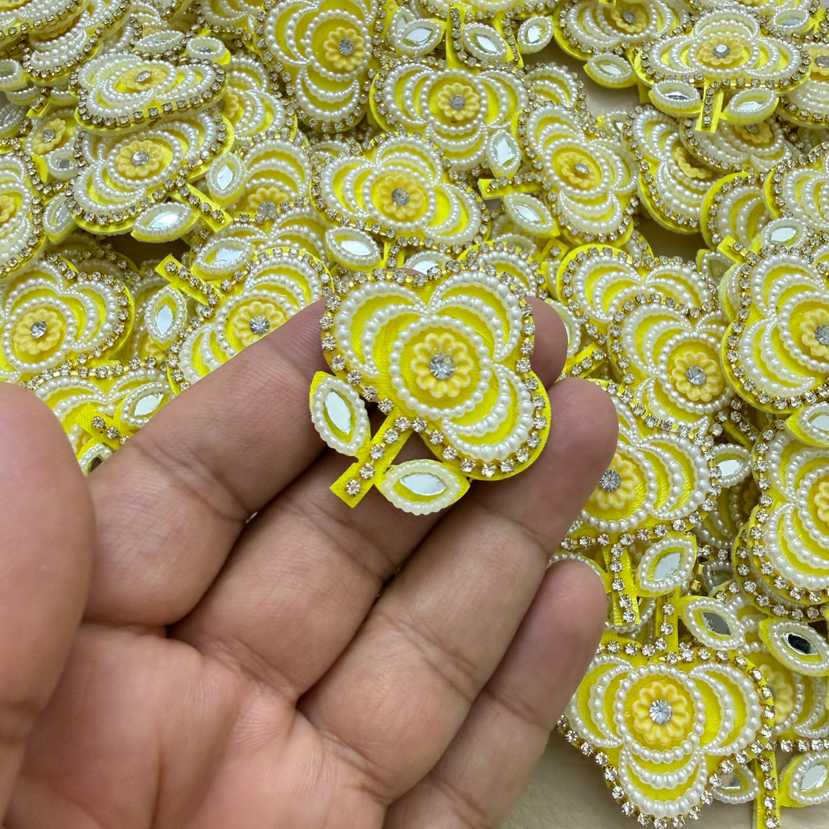 Yellow floral applique patch beside a ruler for size reference