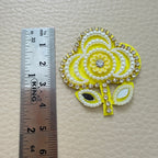 Yellow floral patches with white pearl-look beads, sparkling borders and reflective leaf details