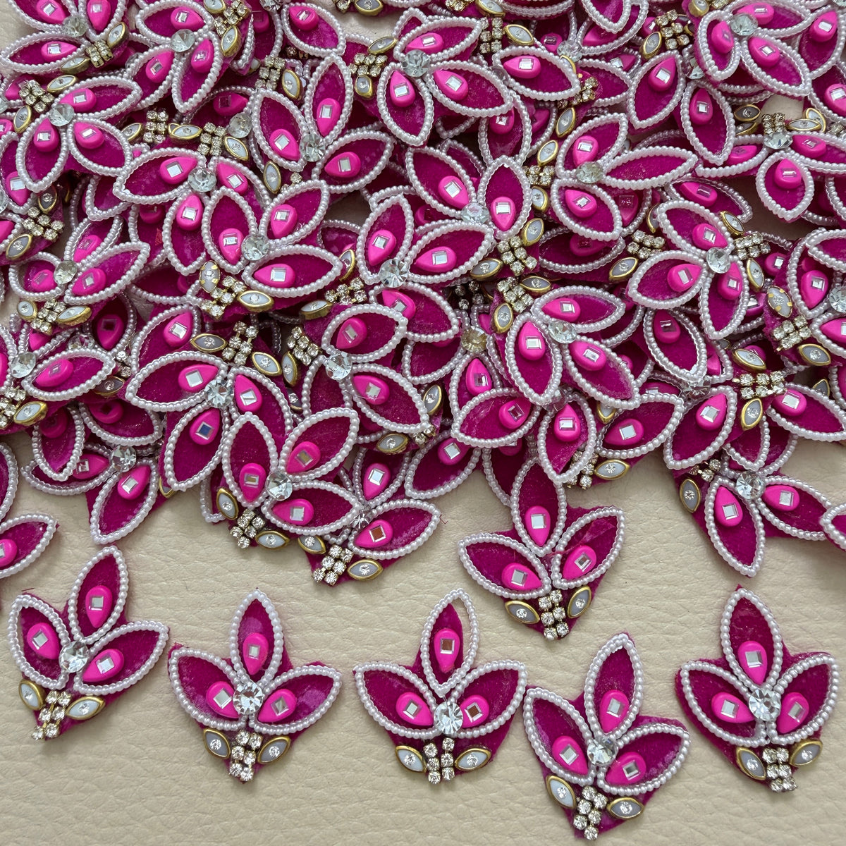 Pink pearl and mirror-look leaf motif patch beside a ruler for size reference