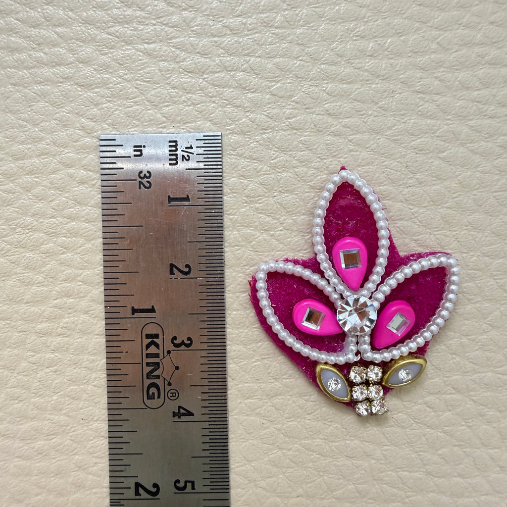 Front and pink fabric backing of leaf motif applique patch