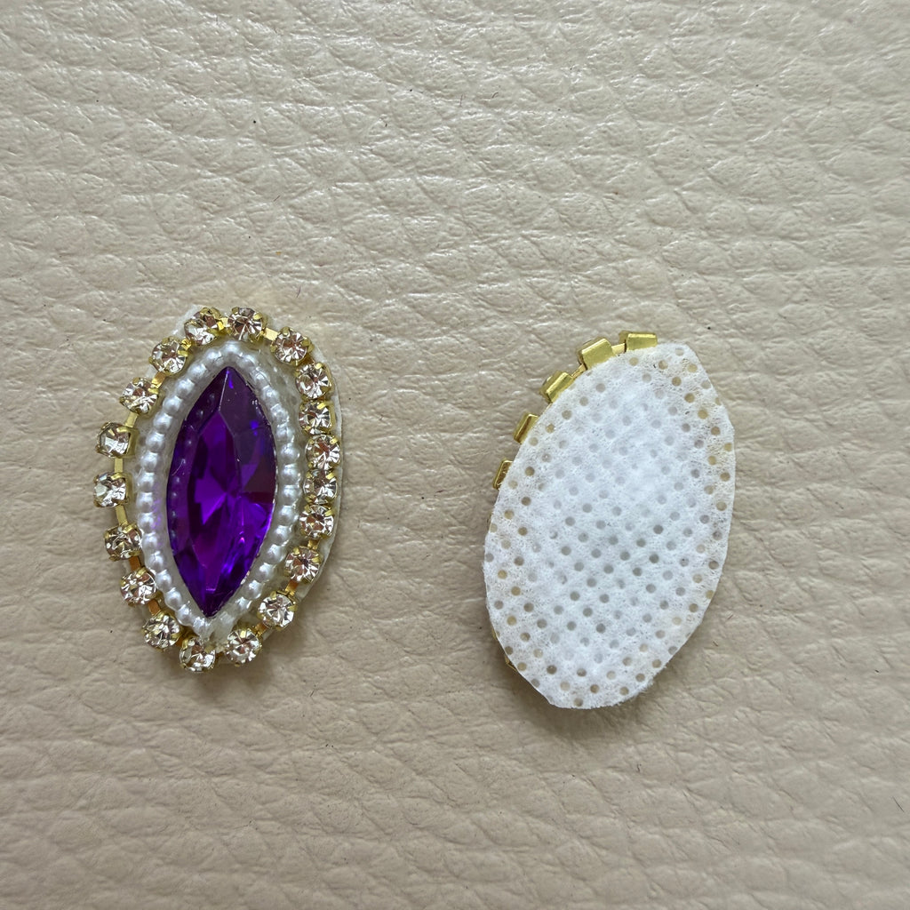 Front and white fabric backing of purple stone applique patch