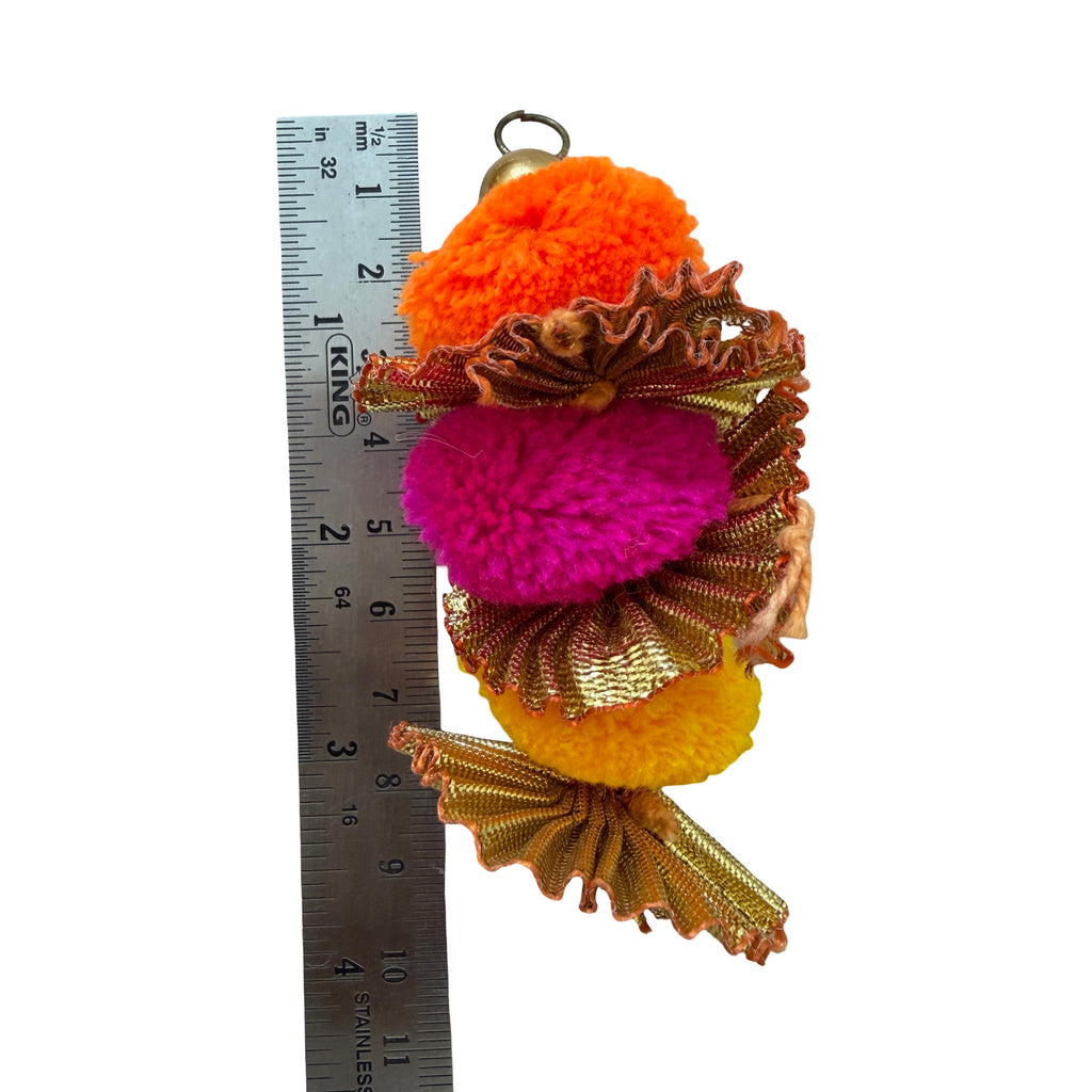 Pom pom latkan tassel held in hand for scale
