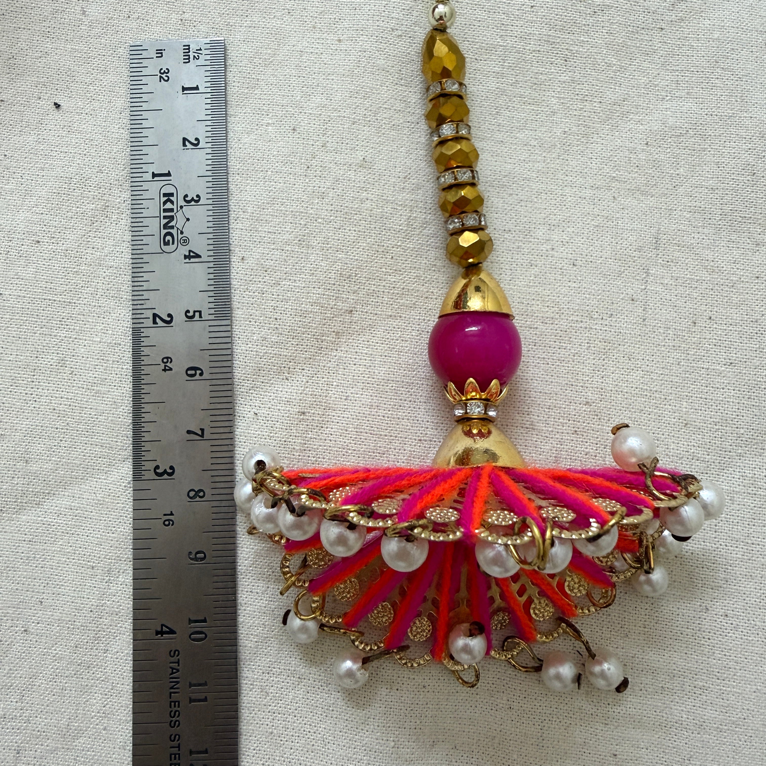 Single fan tassel latkan next to ruler showing approx 18cm length