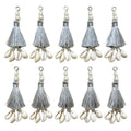 10 silver silk tassels with cowrie shells and pearl beads on white background