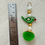 Green Parrot Pom Pom Tassel held in hand showing size and detail