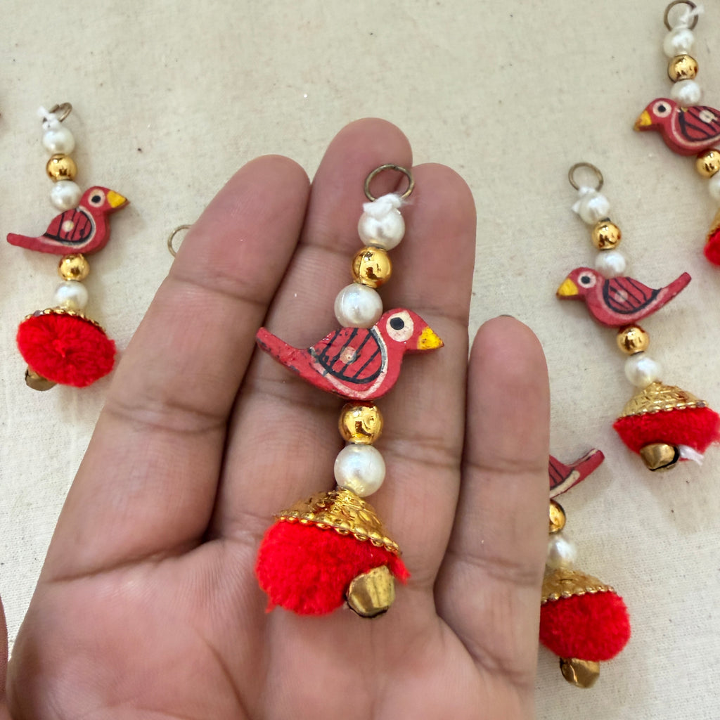 Red Bird Pom Pom Tassel held in hand showing size and detail