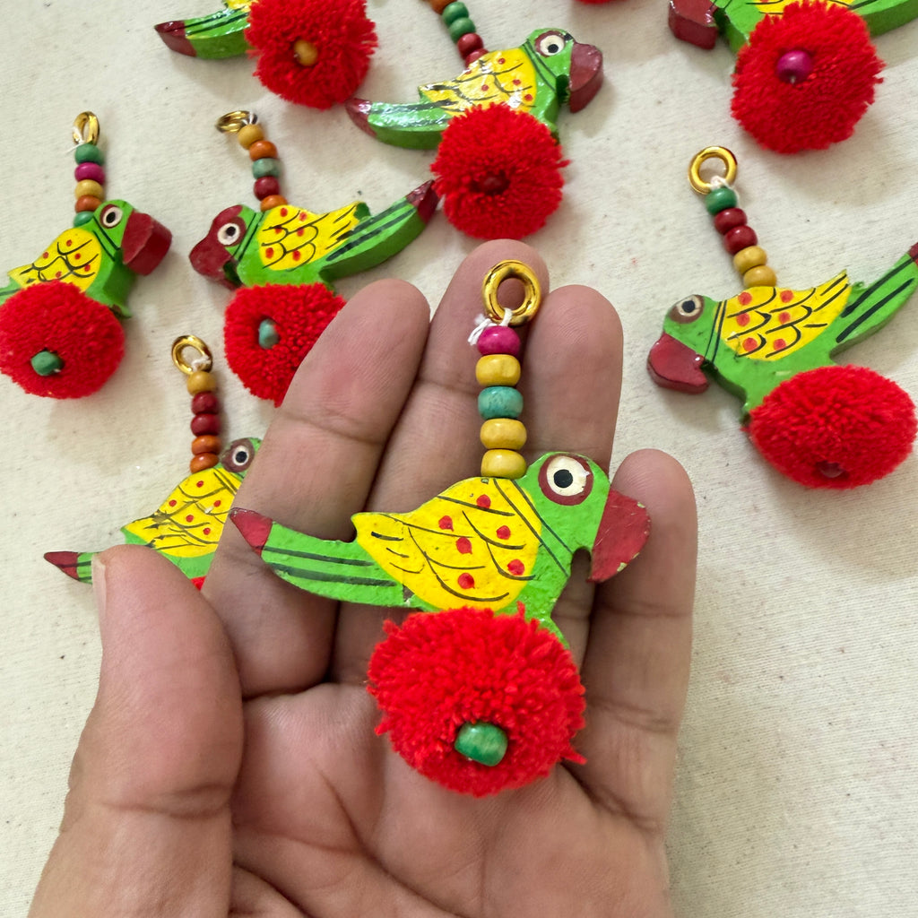 Red Parrot Pom Pom Tassel held in hand showing size and detail