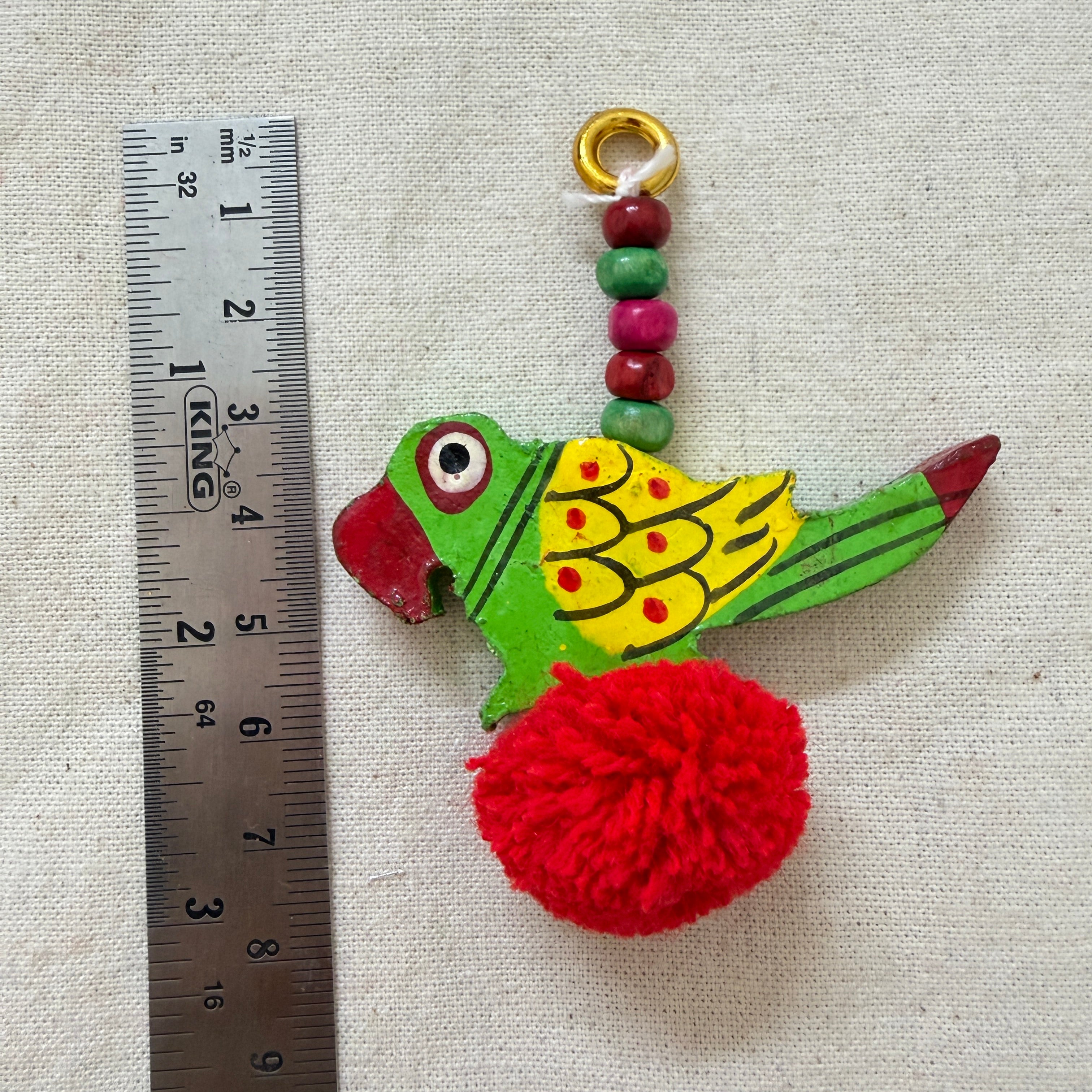Red Parrot Pom Pom Tassel with ruler showing approx 8cm length