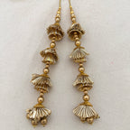 Pair of Gold Gota Jhumka Latkans on cream fabric background