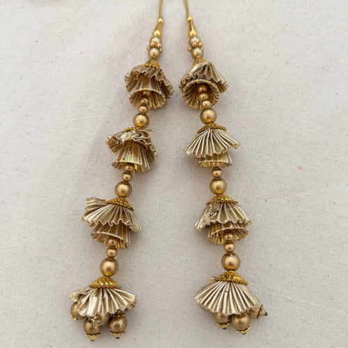 Pair of Gold Gota Jhumka Latkans on cream fabric background