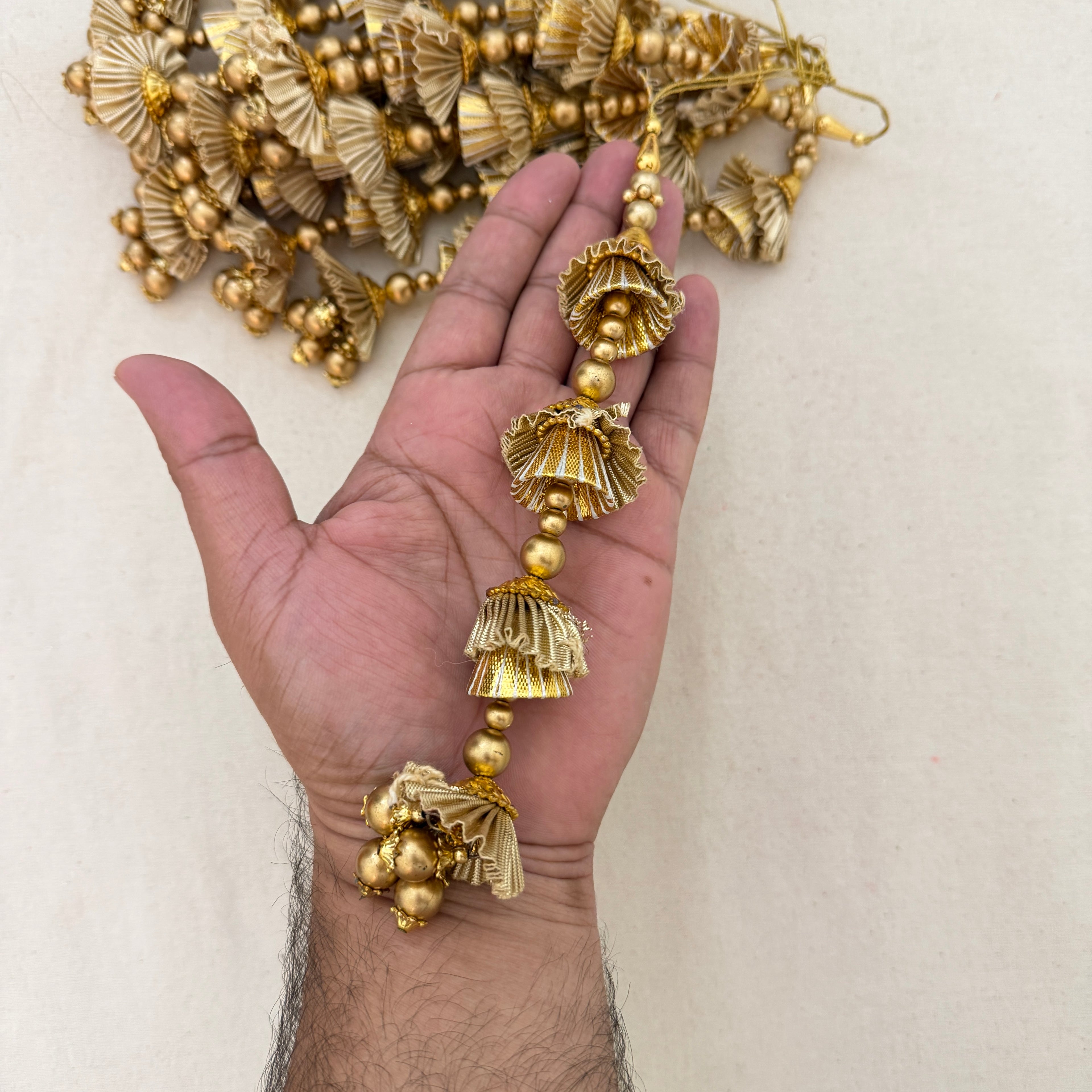 Gold Gota Jhumka Latkan held in hand showing size and detail