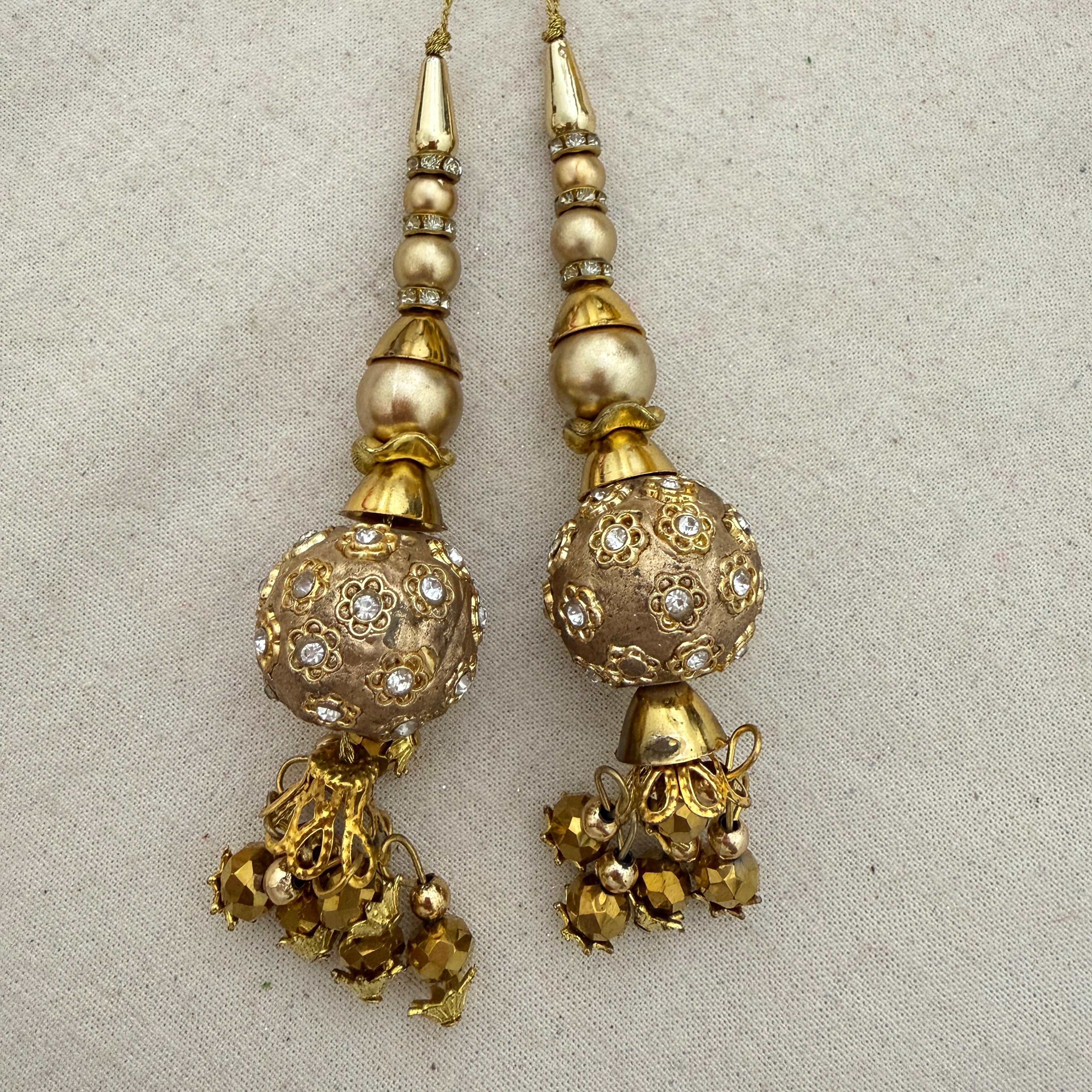 Pair of Rhinestone Floral Ball Latkans on cream fabric background
