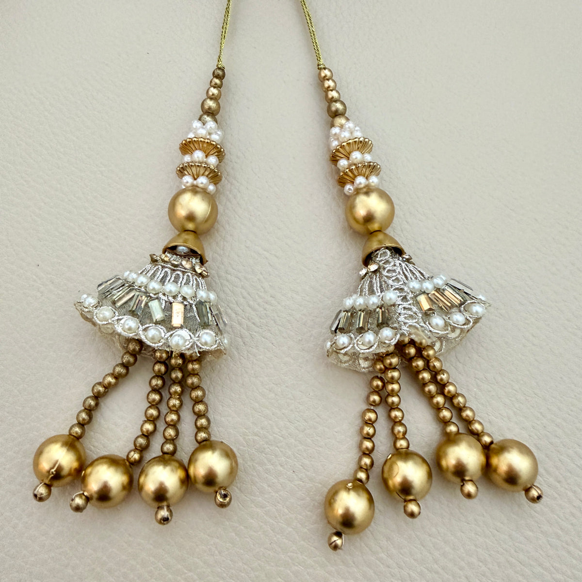 Jhumka latkan tassel pair beside a ruler for size reference