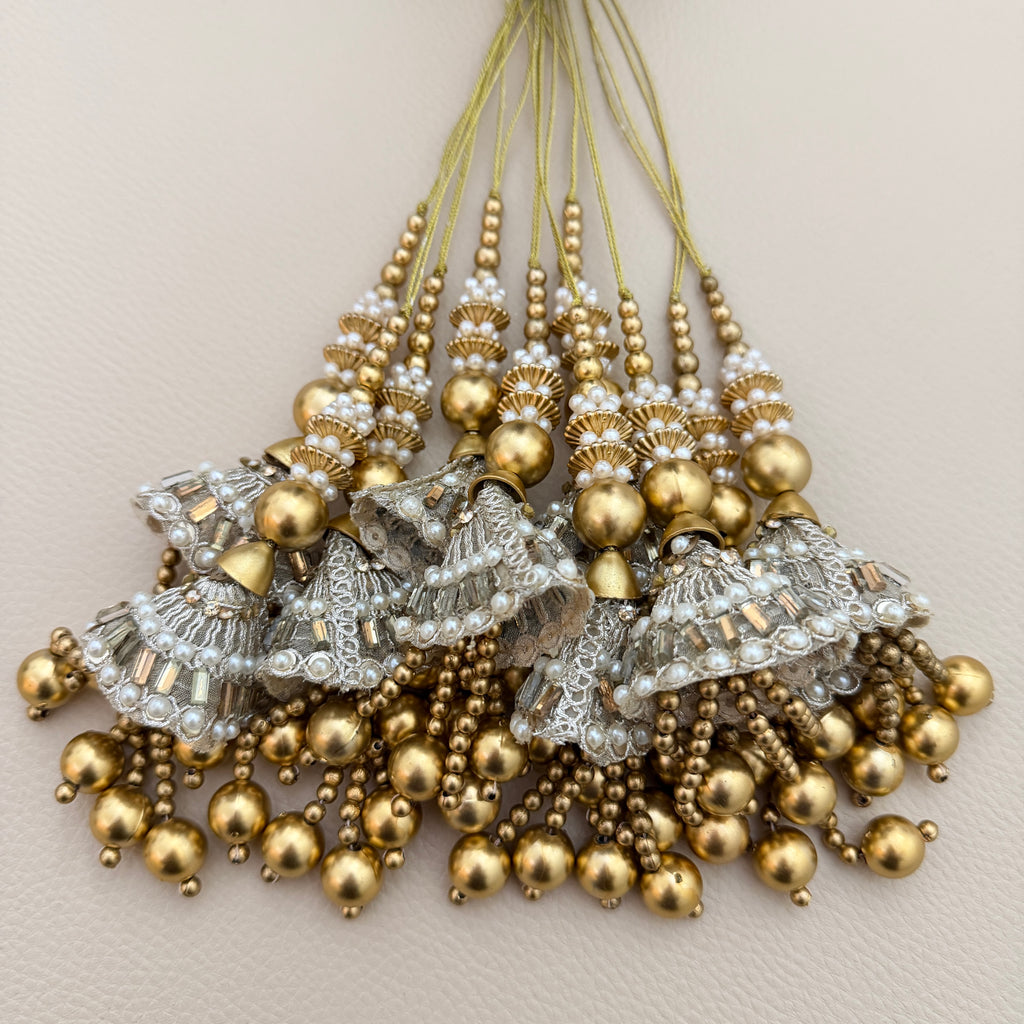 Group of gold and silver-tone jhumka latkan tassels with white bead detailing; sold as a pack of two