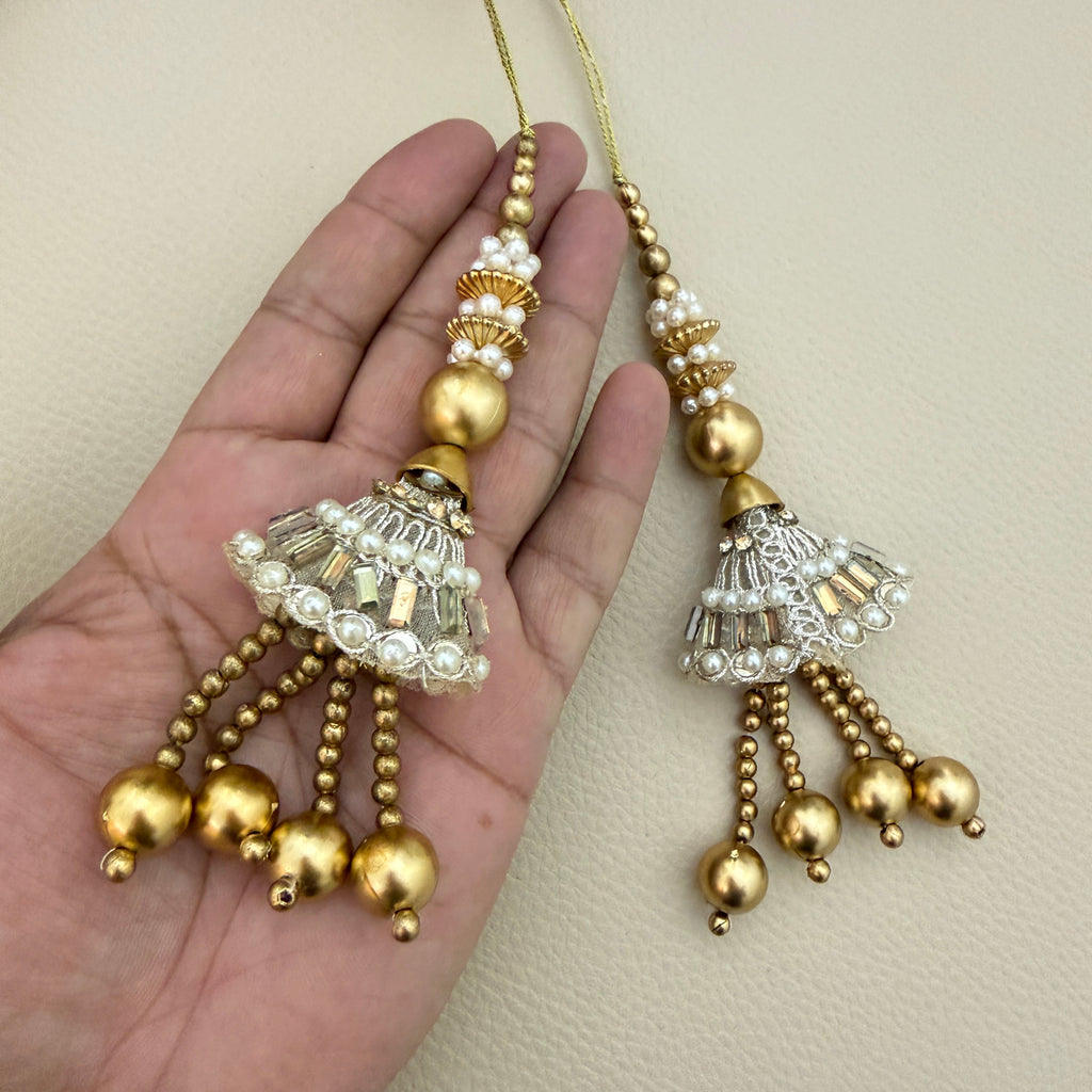 Pair of gold and silver-tone jhumka latkan tassels with white pearl-style accents and dangling gold-tone beads