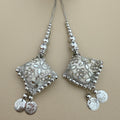 Pair of silver and white diamond-shaped latkan tassels with floral embellishments, beaded cords and dangling coin charms