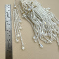 Pair of clear faceted bead latkan tassels with cascading teardrop dangles and white tie cords