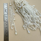 Pair of clear faceted bead latkan tassels with cascading teardrop dangles and white tie cords