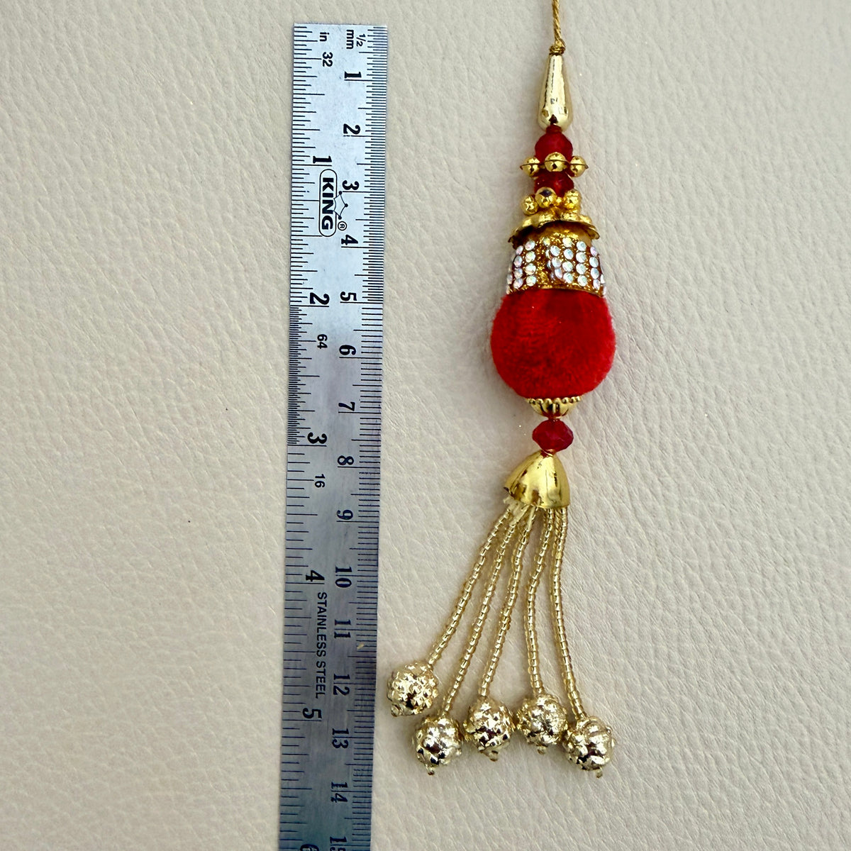 Group view of red pom pom tassels with gold-tone chain drops; sold in packs of two